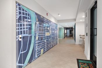 A hallway with a large mural of a city on the wall